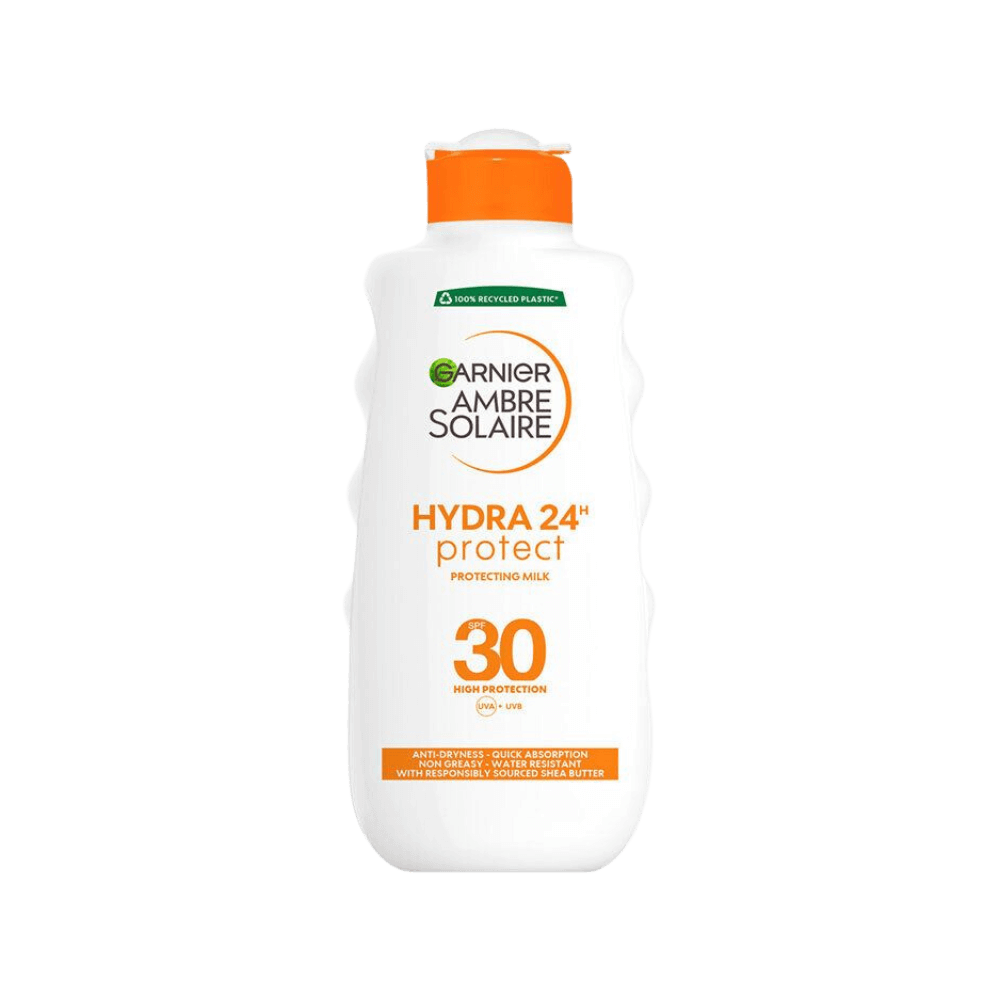 En flaska Garnier Ambre Solaire Hydra 24h Protect SPF 30 solskyddsmjölk. Flaskan är vit med en orange kork och detaljer, erbjuder högt skydd mot UVA- och UVB-strålar, och innehåller sheasmör för extra återfuktning.