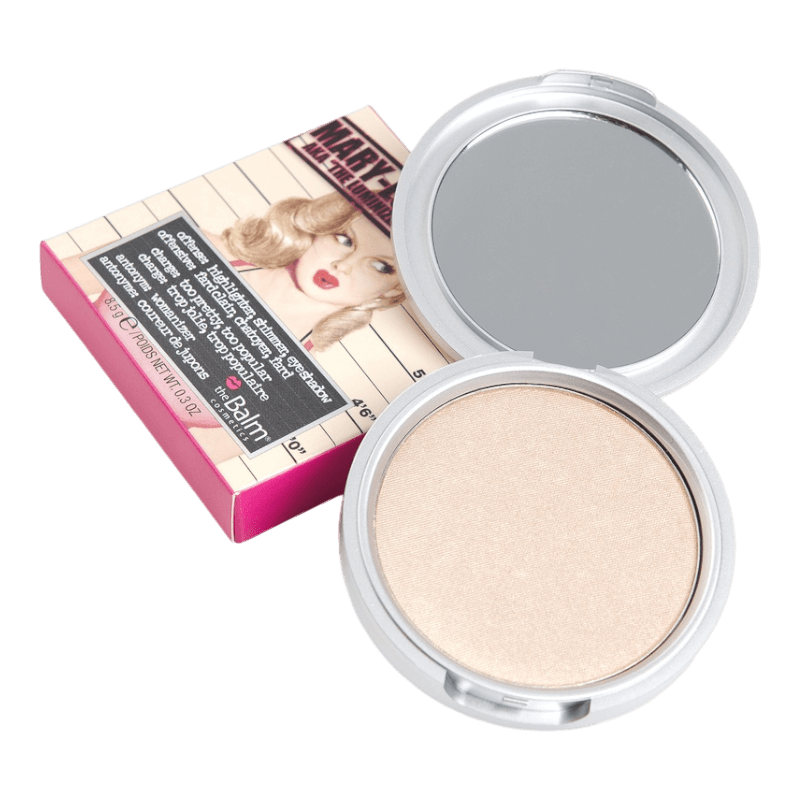 The Balm Mary-Lou Manizer highlighter i en öppen silverfärgad förpackning med spegel, bredvid en dekorativ förpackning med en retroinspirerad illustration av en kvinna.