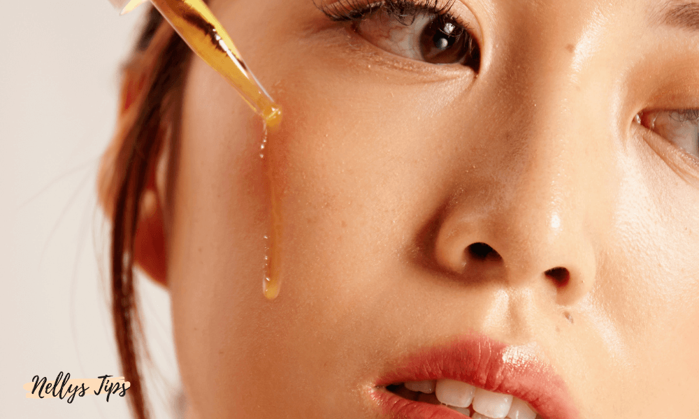 Närbild på ansikte med gyllene serum som droppas på kinden för anti-aging effekt.