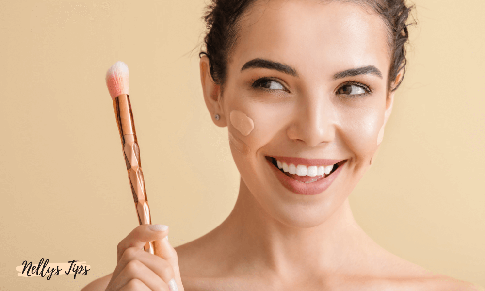 Kvinna som applicerar concealer med borste och ler mot kameran