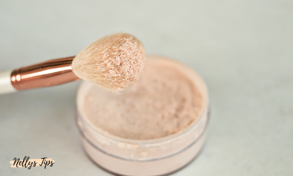 Närbild på makeupborste med löspuder redo för applicering för en naturlig solkysst finish.