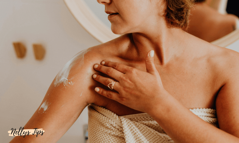Kvinna smörjer in axeln med body lotion för att återfukta torr hud efter dusch.