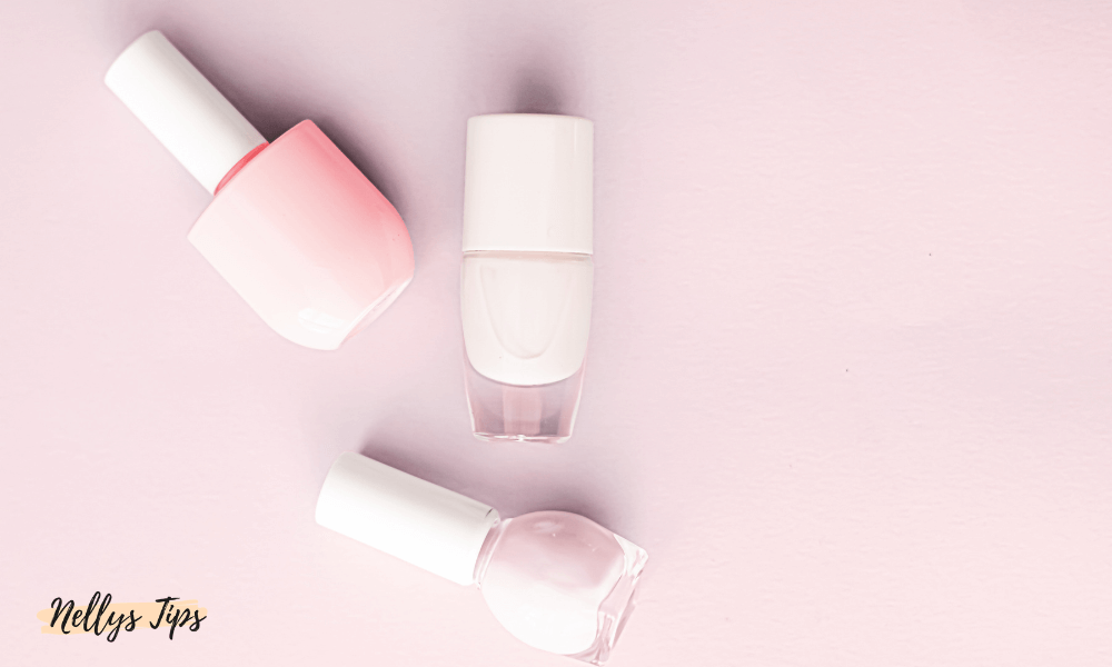 Tre nagellack i rosa toner – stilren flatlay med skönhetsprodukter i pastell på rosa underlag