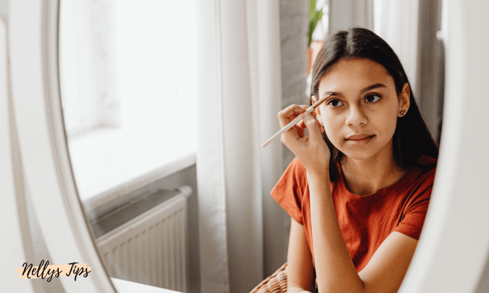 Ung kvinna speglar sig medan hon fyller i ögonbrynen med sminkborste – naturlig look med sminkrutin