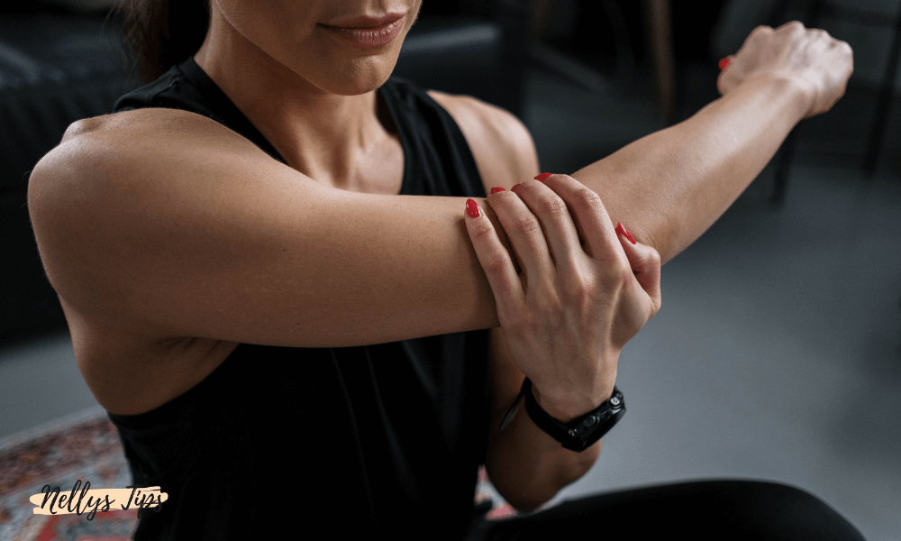 Kvinna håller sig om armbågen under stretch – perfekt vid överansträngning eller återhämtning.
