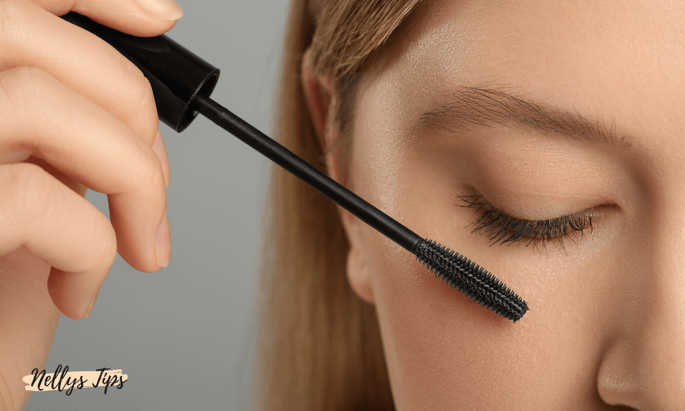 Närbild på kvinna som applicerar svart mascara med silikonborste på övre fransraden