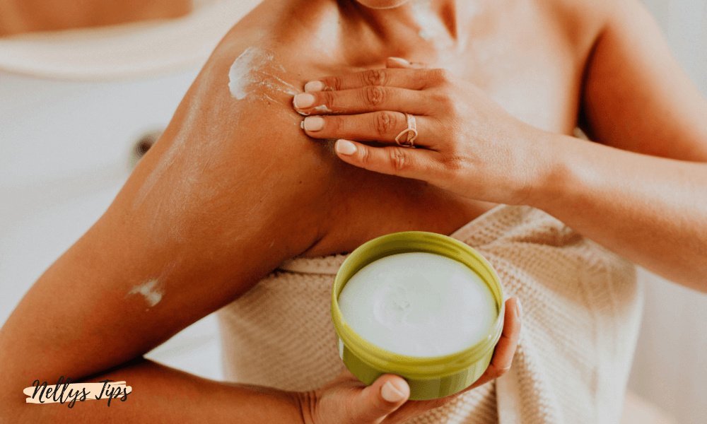 Kvinna applicerar kräm på axeln med en öppen burk bodylotion i handen