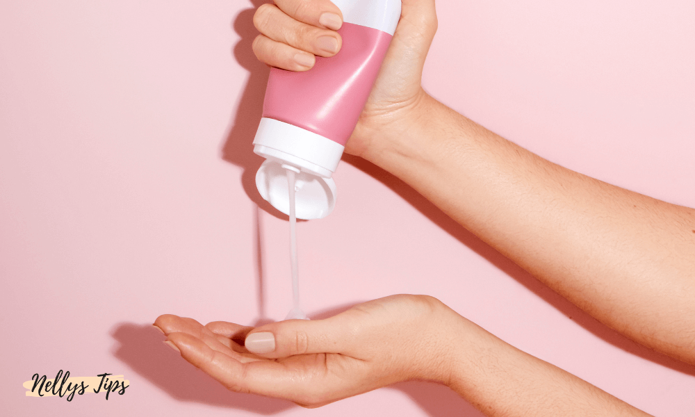 Handkräm i rosa förpackning pressas ut i handen – visar applicering av fuktgivande produkt.