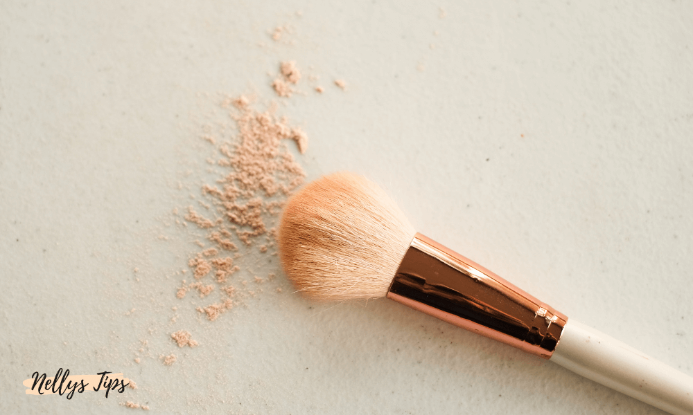 Puderborste med löst puder i beige nyans för applicering av sminkbas