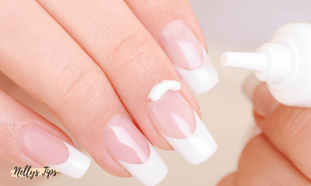 Nagelbandskräm appliceras på fransk manikyr med penselspets för återfuktning av nagelband.