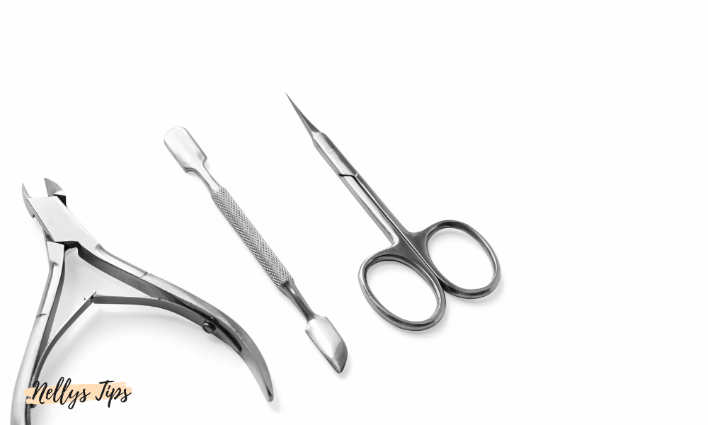 Manikyrverktyg i rostfritt stål – nagelbandsax, nagelbandskniv och pusher på vit bakgrund.
