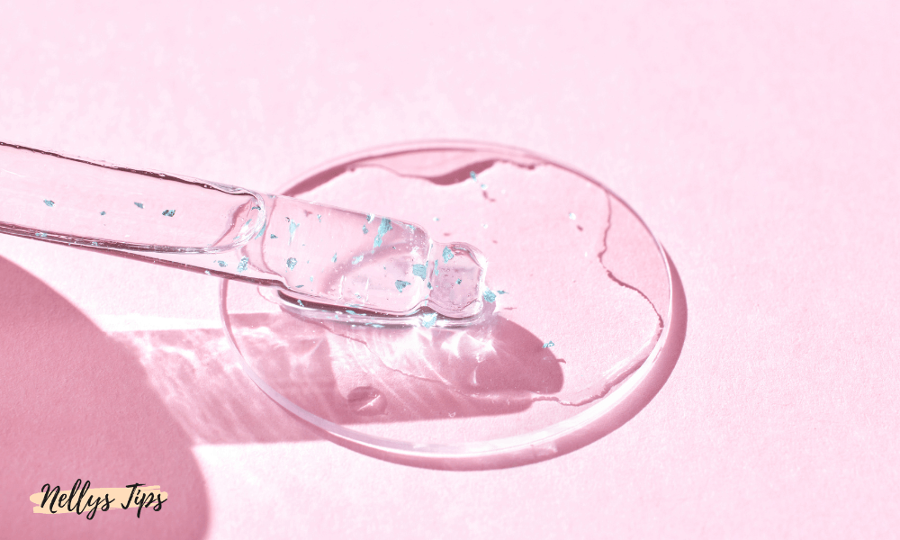 Glaspipett med transparent serum på rosa bakgrund – illustrerar textur och aktiva ingredienser.