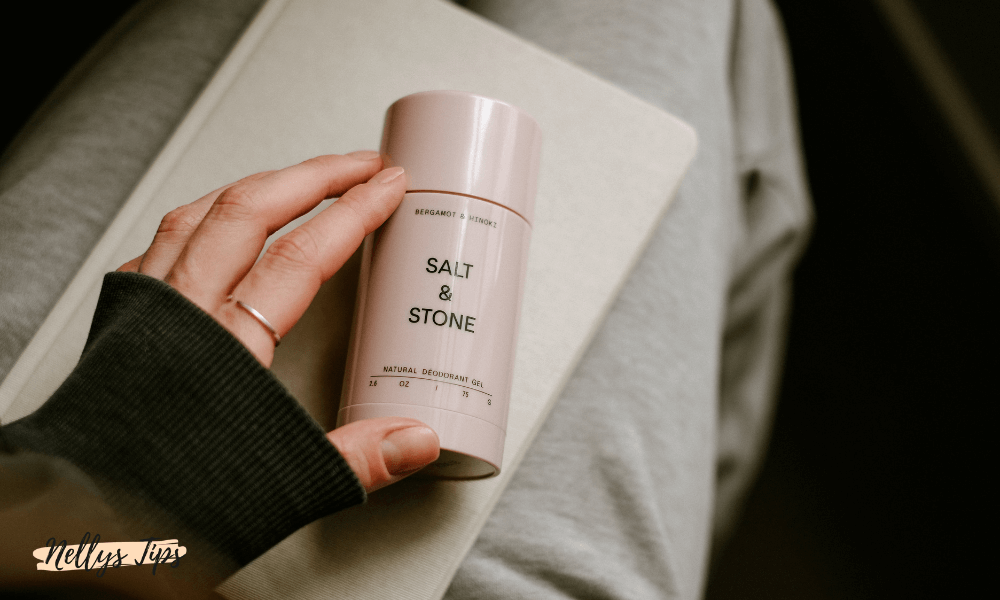 Hand håller i rosa Salt & Stone deodorantgel med bergamot och hinoki-extrakt.