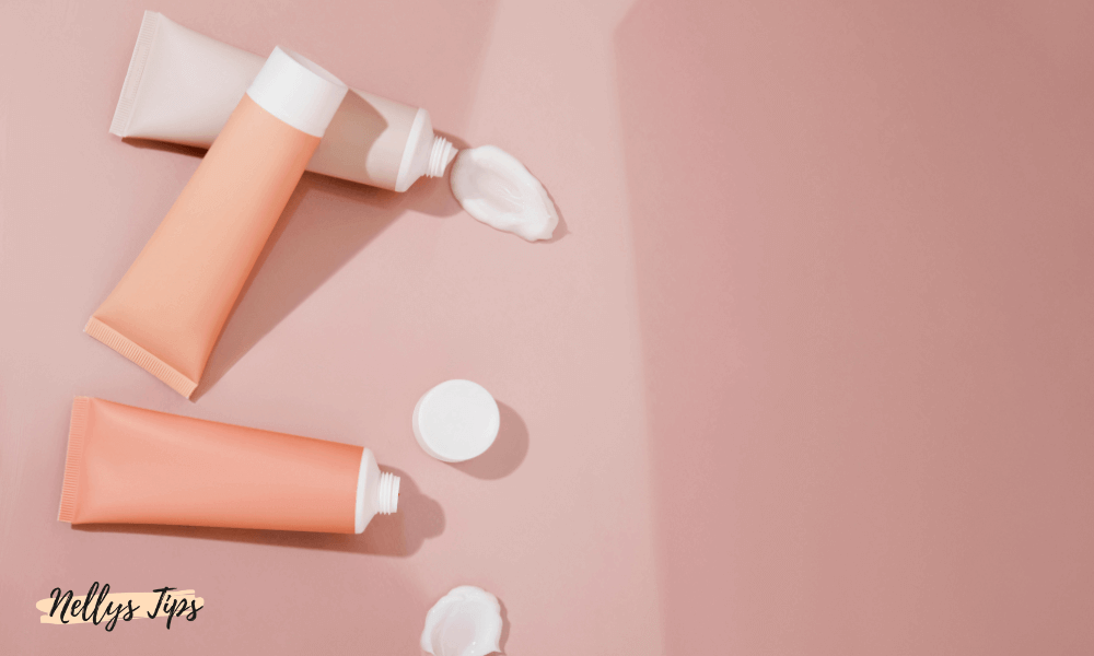 Tre tuber med tonad dagkräm i rosa nyanser med utpressad kräm på en rosa yta