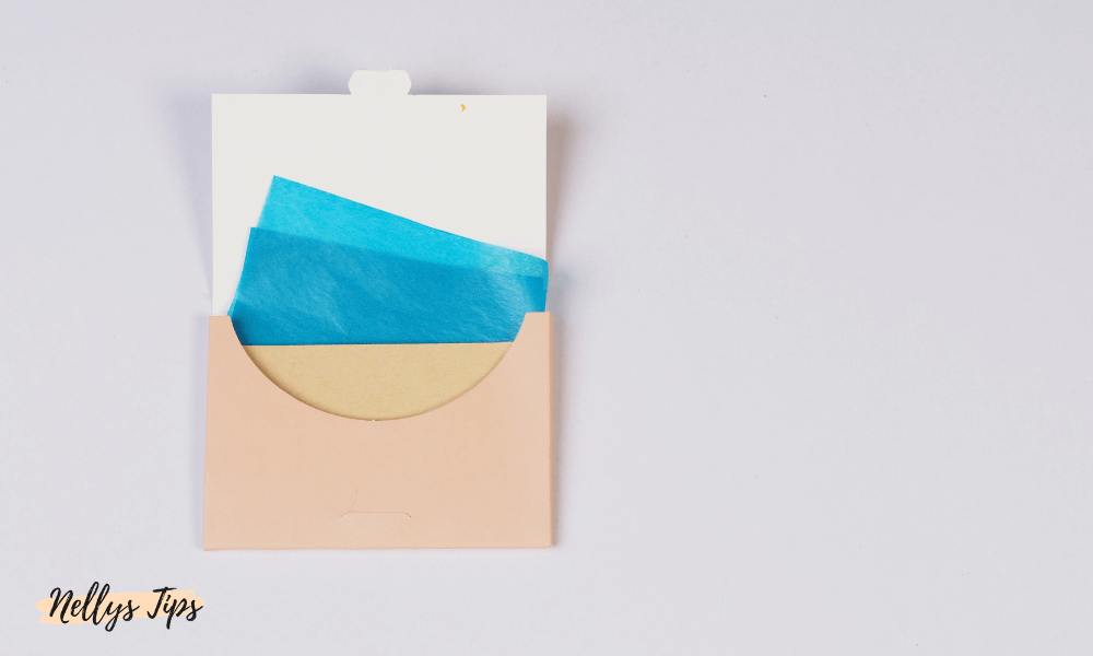 Blå och beige blotting papers i öppen pappersförpackning, praktiska för att ta bort överflödig glans.