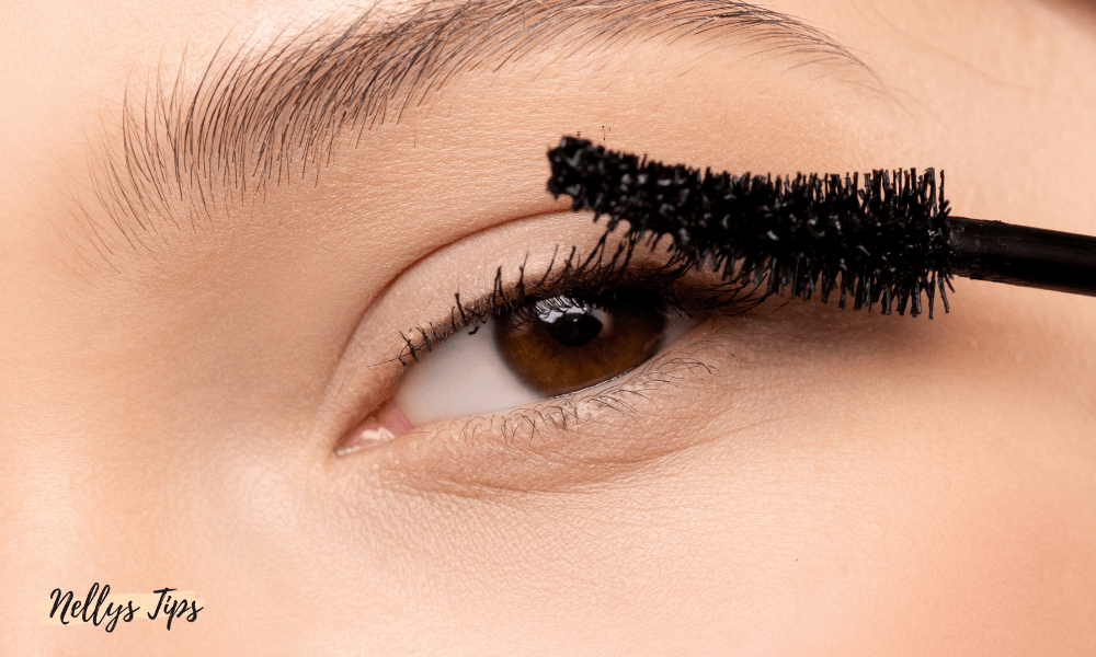 Närbild av öga med brun iris och mascaraapplicering på övre fransrad