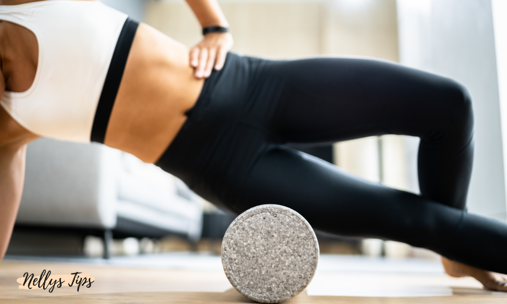 Träningspass med foam roller där kvinna i träningskläder använder den mot höften.