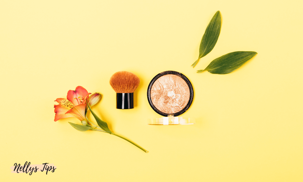 Kabukiborste och highlighter med blomdekoration – sminkstillbehör i vacker flatlay.