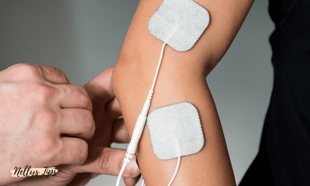 Två elektroder monterade på underarm för smärtlindring via TENS-behandling