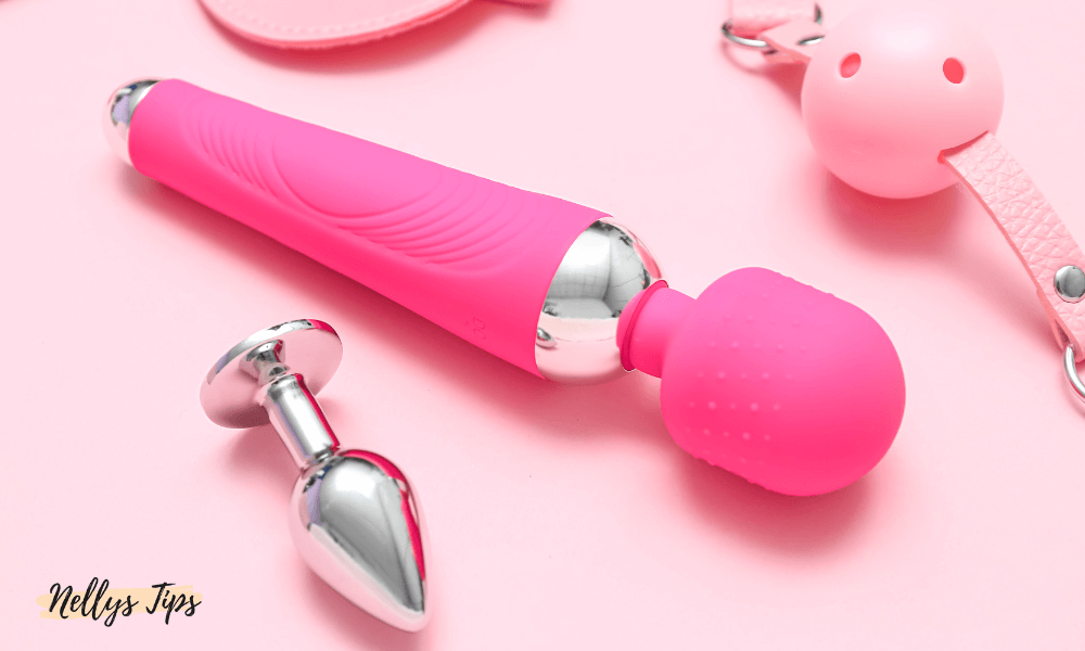 Rosa wandvibrator i metall och silikon tillsammans med metallplugg och tillbehör