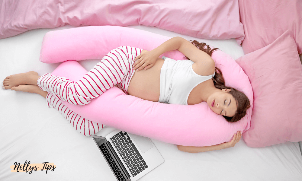 Gravid kvinna sover bekvämt med rosa gravidkudde för optimalt stöd under graviditeten