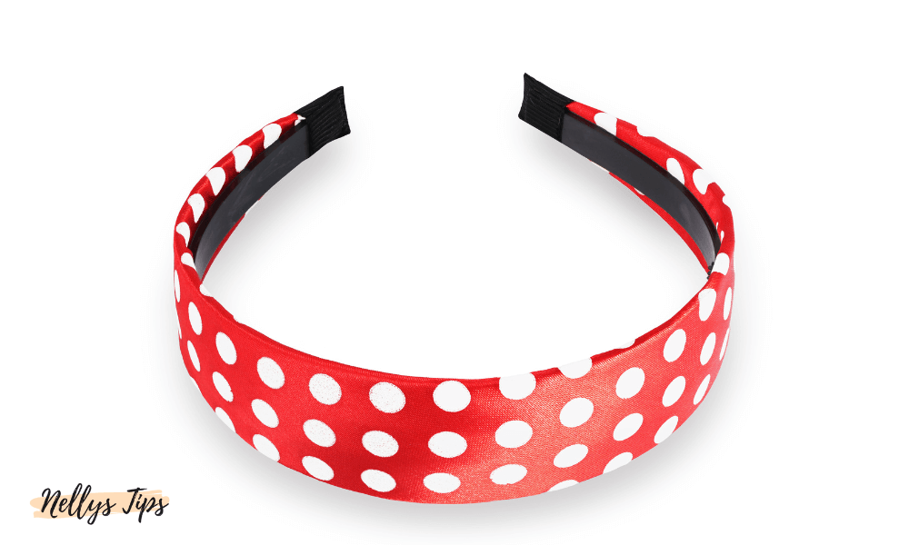 Rött hårband med vita prickar i satinkänsla för en lekfull och retroinspirerad stil.
