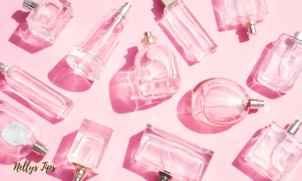 Platta parfymflaskor för hårparfym i olika former och stilar arrangerade på rosa underlag.