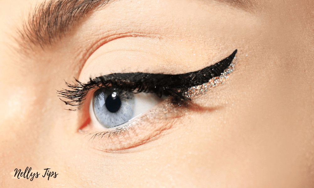 Närbild på öga med glitter-eyeliner och markerat ögonlock för dramatisk sminklook.