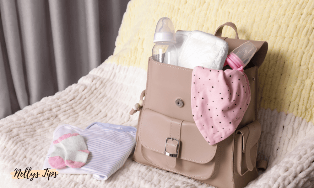 Beige skötväska fylld med babyprodukter på säng, perfekt för resor med småbarn