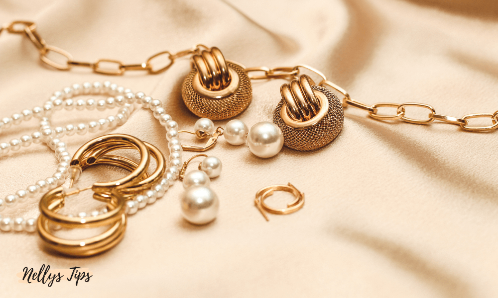 Guldsmycken och pärlor på beige tyg – lyxigt arrangemang med örhängen och armband