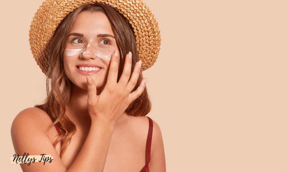 Kvinna applicerar solkräm i ansiktet med hatt – redo för solen med tan enhancer produkter