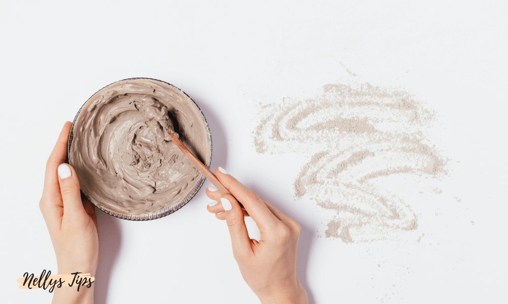 Kvinna rör om en skål med lermask redo att appliceras för handvård och exfoliering.