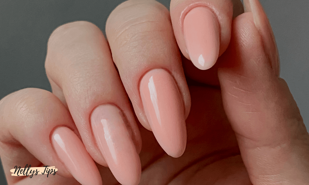 Närbild på hand med mandelformade naglar i rosa polygel
