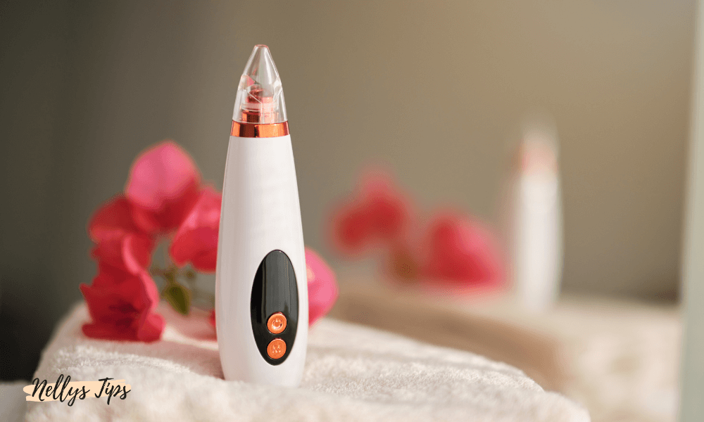 Vit pormasksugare med svart kontrollpanel placerad på en handduk med blommor i bakgrunden