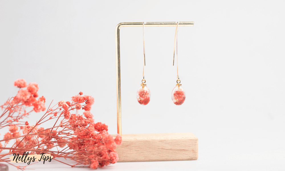 Minimalistiskt smyckesställ i mässing med örhängen och torkade blommor i dekoration