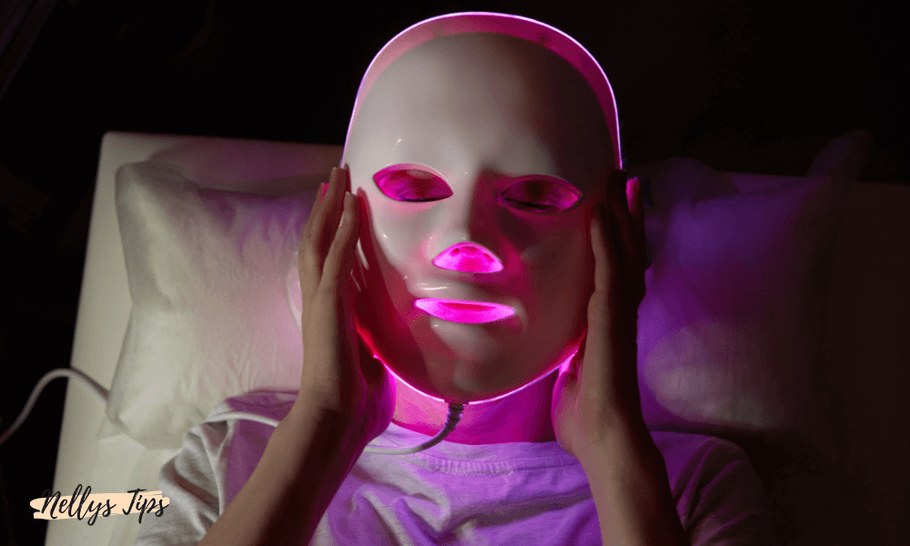 Person använder LED-ansiktsmask med rosa ljus för hudföryngring och förbättrad hudstruktur