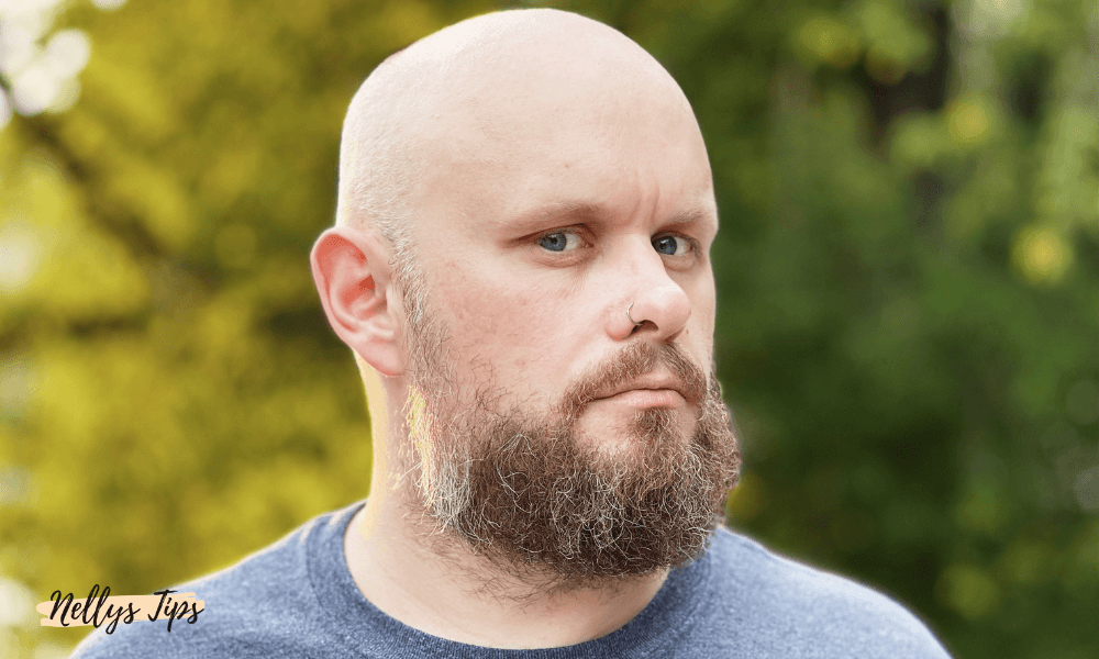 Man med fylligt skägg visar resultatet av skäggvård med skäggschampo.