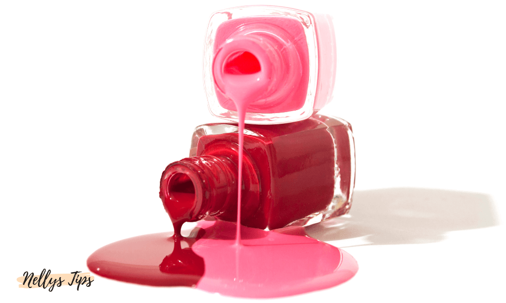 Två öppna nagellacksflaskor med röd och rosa färg som rinner ut på ytan.