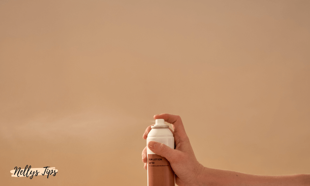 Hand som sprayar ut ett solskydd i mistform för att skydda huden från UV-strålning