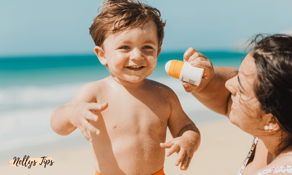 Leende barn på stranden får solskydd SPF 50 applicerat, perfekt för solskyddstips till barn.