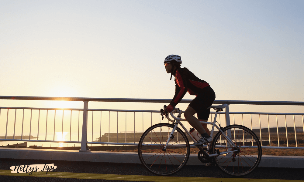 Kvinna cyklar i solnedgång med hjälm och cykelbyxor – inspiration till bästa cykelbyxorna för dam.