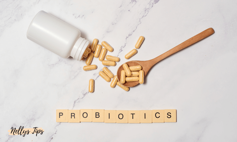 Probiotikakapslar med träsked och scrabble-bokstäver som stavar PROBIOTICS för maghälsa.